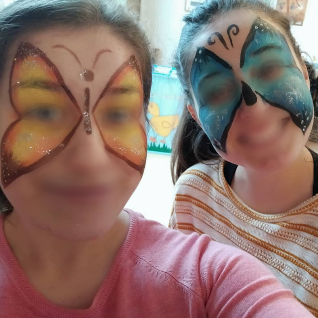 Actividade de pintacaras para crianzas durante unha festa ou evento familiar.