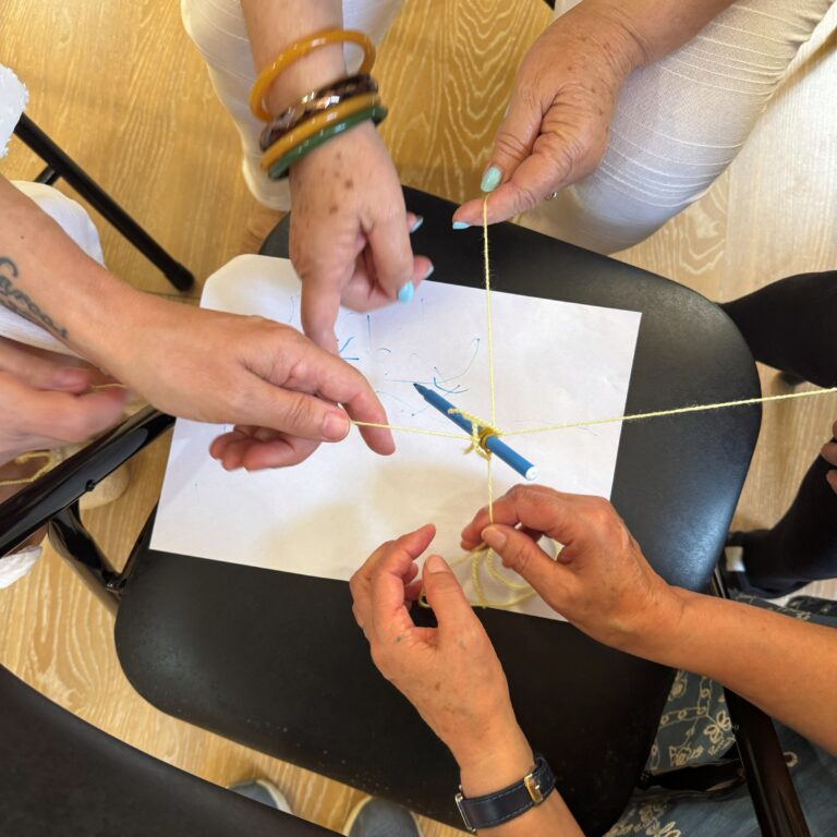 Participantes elaborando unha creación artística cooperativamente nun obradoiro de risoterapia