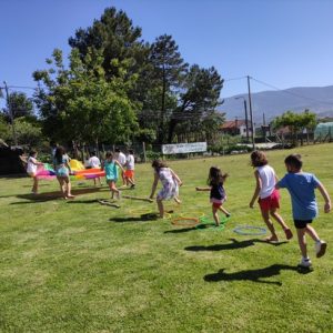 Grupo de crianzas participando en xogos cooperativos para fomentar o traballo en equipo e a participación.